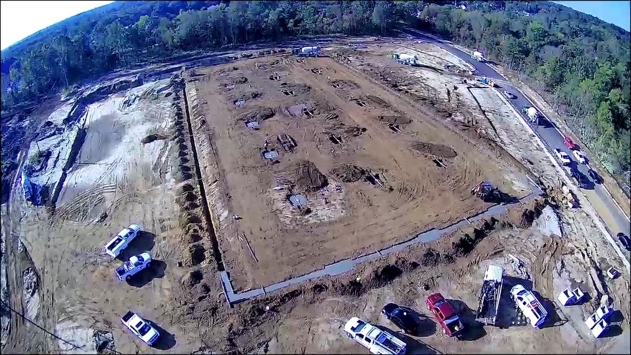 Aerial view of full construction site layout with equipment and trucks